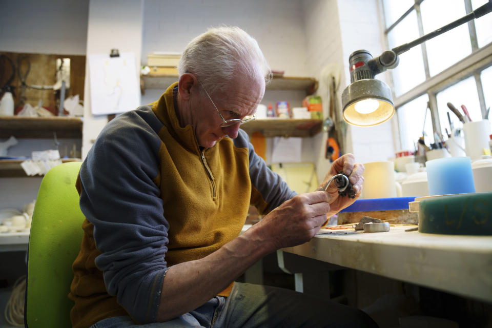 Model Maker Gordon Brooks uses bismuth, a soft metal, to fashion a handle mould, at the Duchess China 1888 factory, in Stoke-on-Trent, England, Thursday, March 30, 2023. With just five weeks to go until King Charles III’s coronation, an historic pottery is busy producing “God Save The King” commemorative china plates and mugs to mark the occasion. (AP Photo/Jon Super)