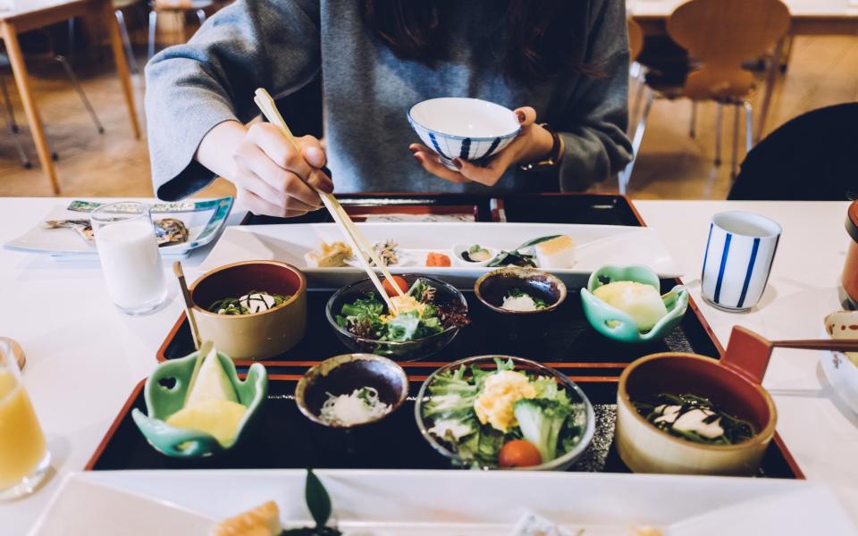 Woman eating with chopsticks in a Japanese restaurant