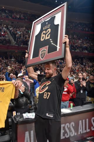<p>David Liam Kyle/NBAE via Getty</p> Travis Kecle holds a framed Cavaliers jersey with his brother Jason's number 62