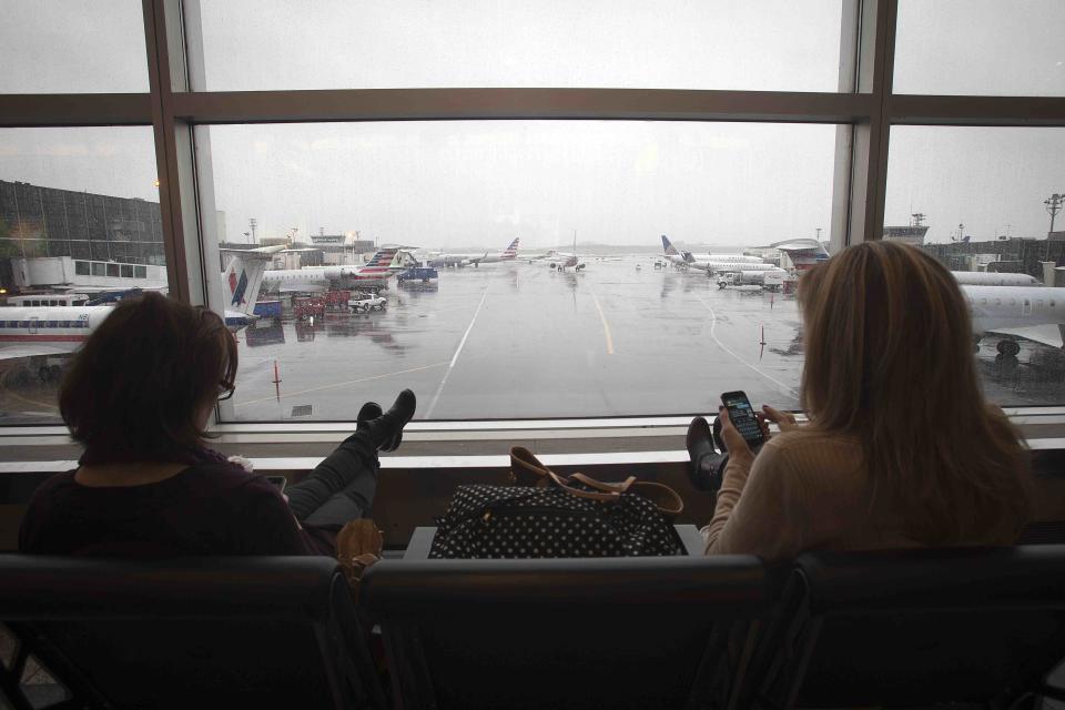 People rest at LaGuardia airport on the day before Thanksgiving, in New York