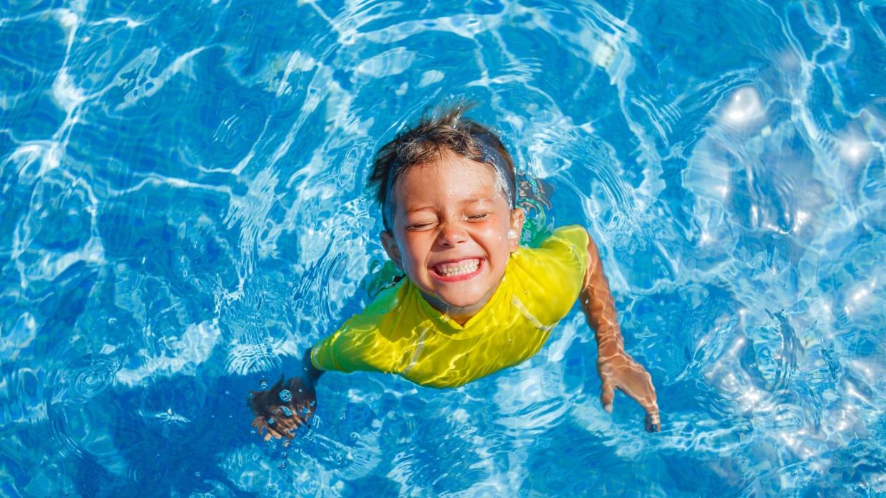 Niño bañándose feliz en la piscina