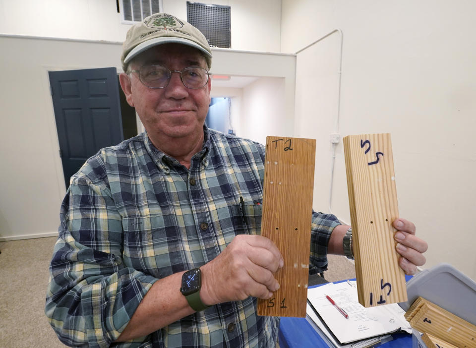 Co owner of Building Resilient Solutions, Kerry Shackelford displays pine boards that they use to test flood resistance at his lab Tuesday, Oct. 4, 2022, in Suffolk , Va. Whenever historic homes get flooded, building contractors often feel compelled by government regulations to rip out the water-logged wood flooring, tear down the old plaster walls and install new, flood-resistant materials. But Virginia restorers Paige Pollard and Kerry Shackelford say they can prove that historic building materials can often withstand repeated flooding. (AP Photo/Steve Helber)