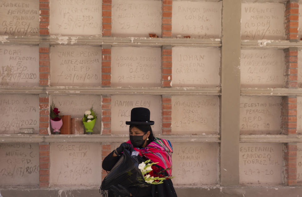 Una mujer pasa frente a tumbas de personas que fallecieron por complicaciones de COVID-19 en el Cementerio General de La Paz, Bolivia, el miércoles 23 de septiembre de 2020. (AP Foto/Juan Karita)
