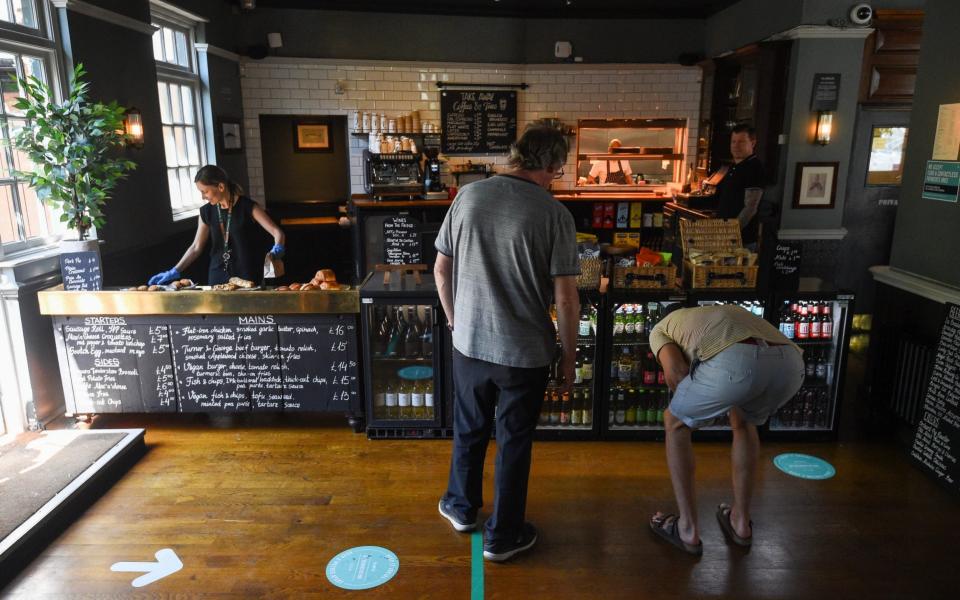 Customers use a one way system at The Crabtree pub in Fulham, London - PA