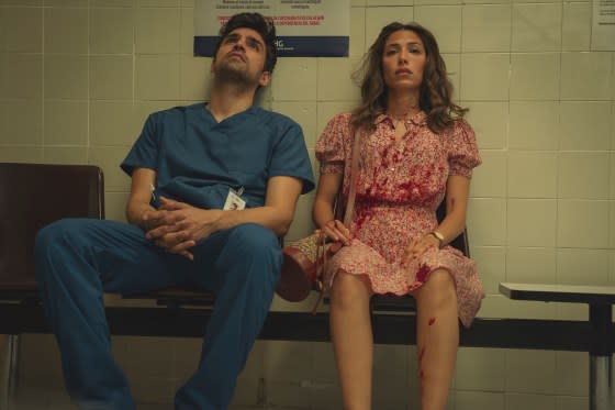 Jordi (Sean Teale), Erin's husband, who is also a nurse, sits next to a bloodied Erin (Evin Ahmad) in the hospital. <span class="copyright">Sam Taylor—Netflix</span>