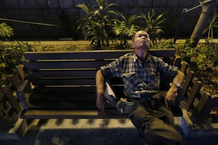 Lou Tit-Man, 73, takes a nap in a park in Hong Kong