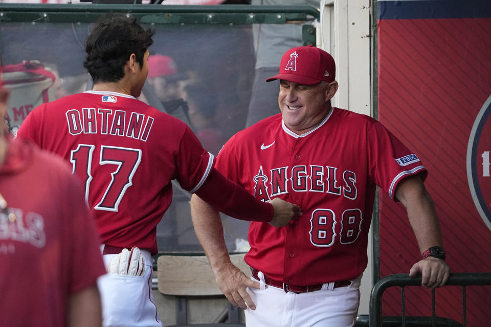 Los Angeles Angels' Shohei Ohtani, left, pokes manager Phil Nevin in the stomach prior to a baseball game against the Cincinnati Reds Tuesday, Aug. 22, 2023, in Anaheim, Calif. (AP Photo/Mark J. Terrill)