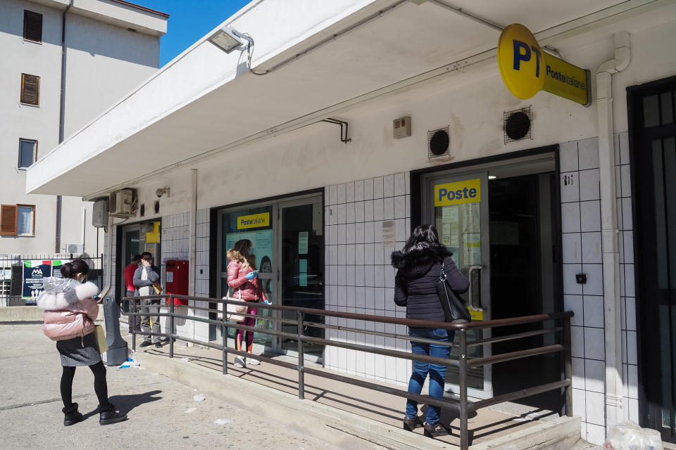 People keeping a safe distance queuing outside a post office...