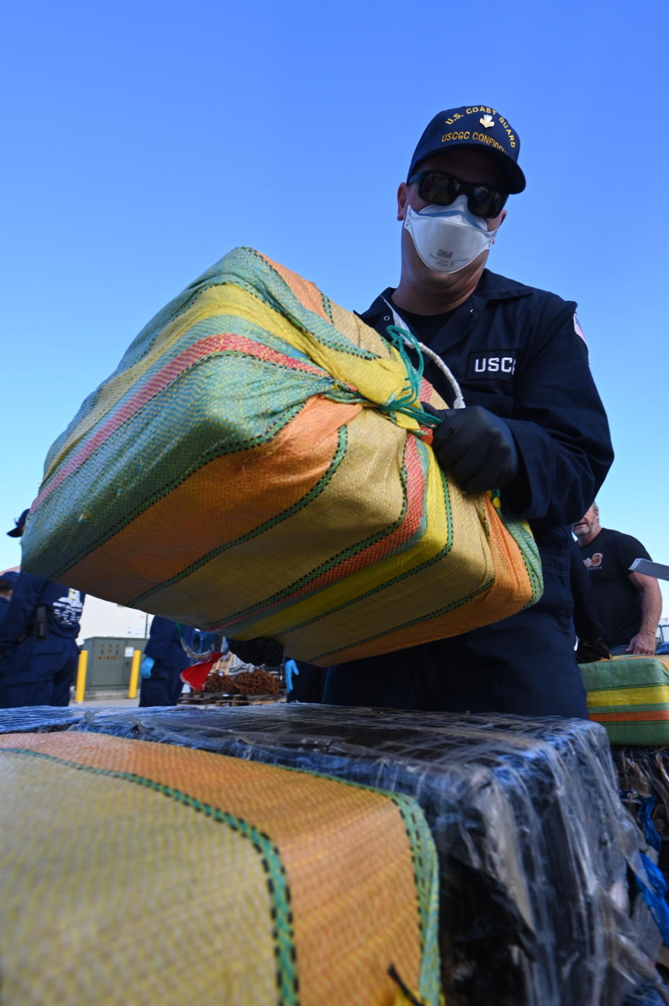 Crew member of Coast Guard Cutter Confidence offloading big cocaine haul from nine different cases in Miami, Florida.