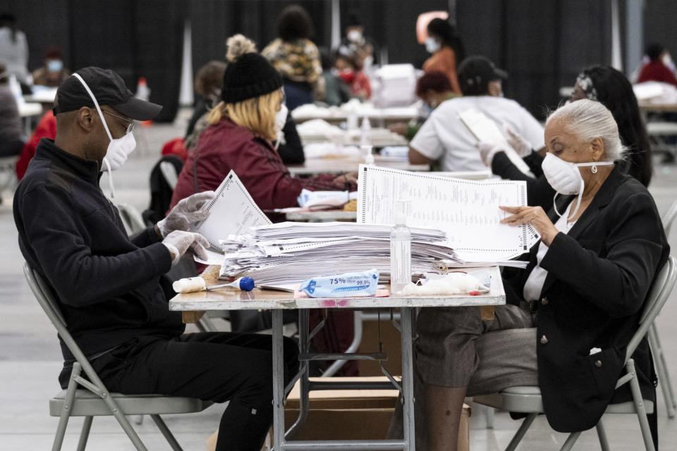 Workers sort and stack ballots in preparation for scanning during a recount, Tuesday, Nov. 24, 2020, in Lithonia, Ga. County election workers across Georgia have begun an official machine recount of the roughly 5 million votes cast in the presidential race in the state. The recount was requested by President Donald Trump after certified results showed him losing the state to Democrat Joe Biden by 12,670 votes, or 0.25% (AP Photo/Ben Gray)