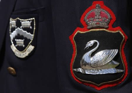 A badge depicting a swan is pictured on the uniform of the Vintner Swan Marker during the annual Swan Upping ceremony on the River Thames between Shepperton and Windsor in southern England July 14, 2014. REUTERS/Luke MacGregor