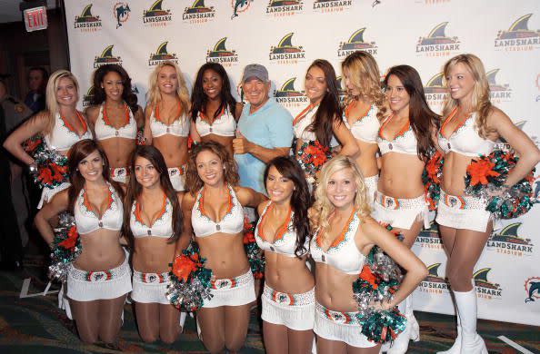 MIAMI GARDENS, FL - MAY 08: Jimmy Buffett poses with Miami Dolphins Cheerleaders for the renaming of Dolphin Stadium to LandShark Stadium on May 8, 2009 in Miami Gardens, Florida. (Photo by Alexander Tamargo/Getty Images)