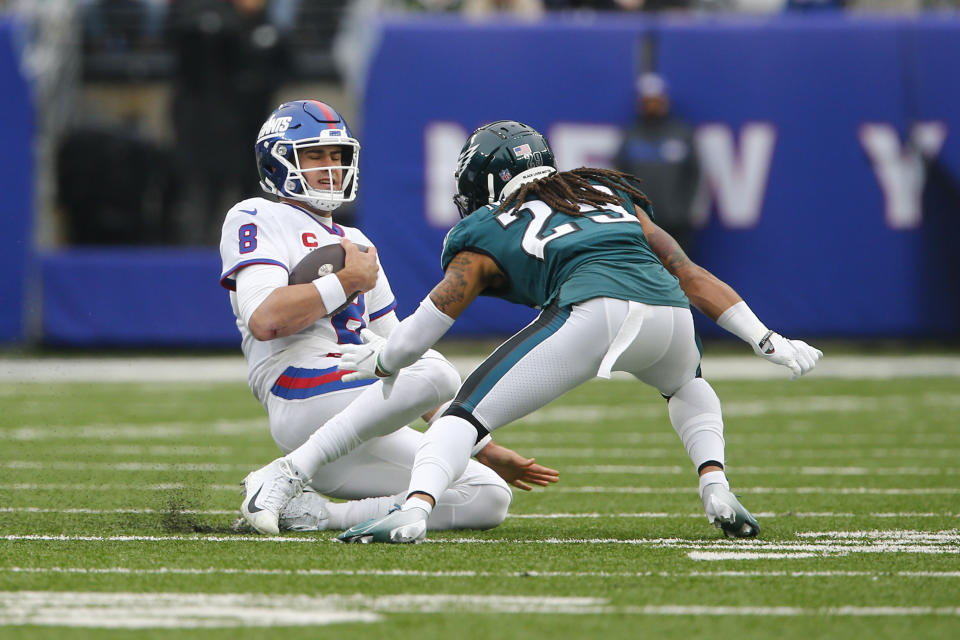 New York Giants quarterback Daniel Jones, left, slides down when confronted by Philadelphia Eagles' Avonte Maddox during the first half of an NFL football game, Sunday, Nov. 28, 2021, in East Rutherford, N.J. (AP Photo/John Munson)