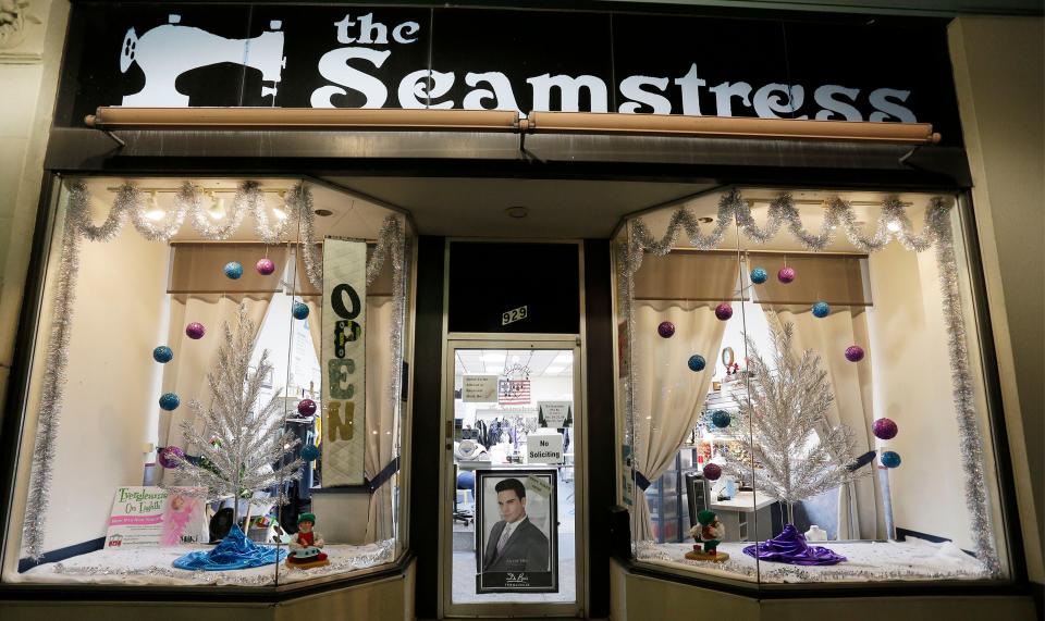 Aluminum Christmas trees appear in the windows of The Seamstress, Tuesday, December 21, in Manitowoc, Wis. with the Evergleams on Eighth program. 