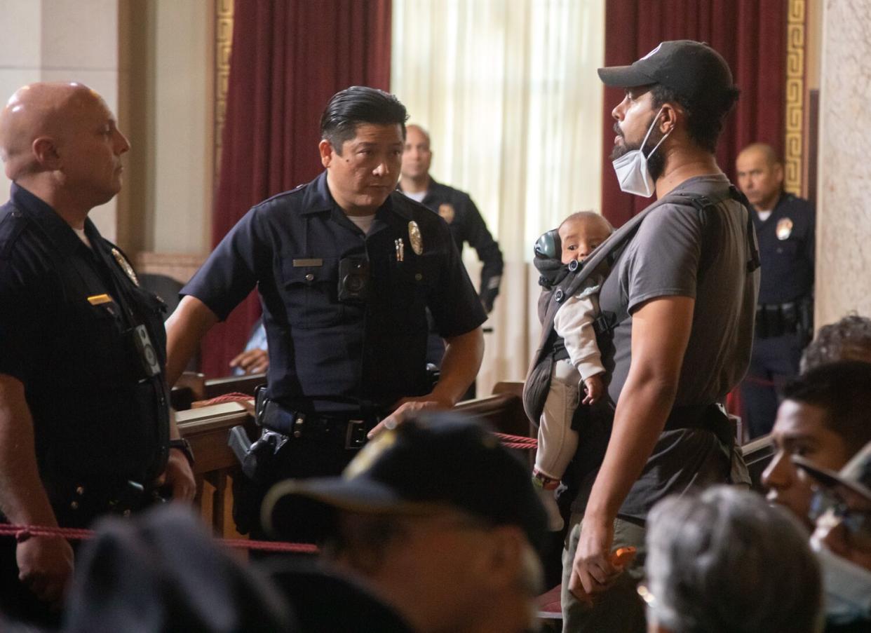 Police officers watch Jason Reedy during city council hearing.