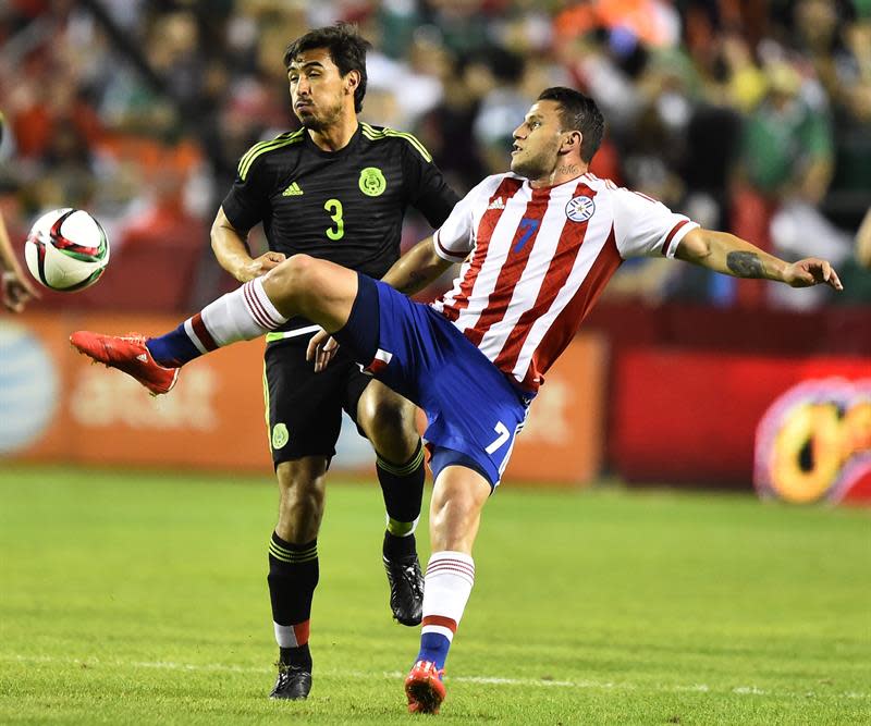 LWS104. KANSAS CITY (MO, EE.UU.), 31/03/2015.- El jugador mexicano Oswaldo Alanis (i) marca al paraguayo Raúl Bobadilla (d) hoy, martes 31 de marzo de 2015, durante un partido amistoso entre México y Paraguay en el estadio Arrowhead de Kansas City, Misuri (EE.UU.). EFE/Larry W. Smith