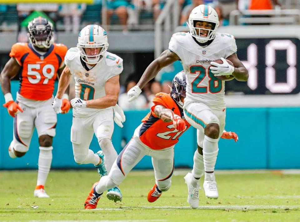 Miami Dolphins running back De’Von Achane (28) gets ahead of the tackle attempt by Denver Broncos cornerback Essang Bassey (21) to score a touchdown in the fourth quarter at Hard Rock Stadium in Miami Gardens on Sunday, September 24, 2023.