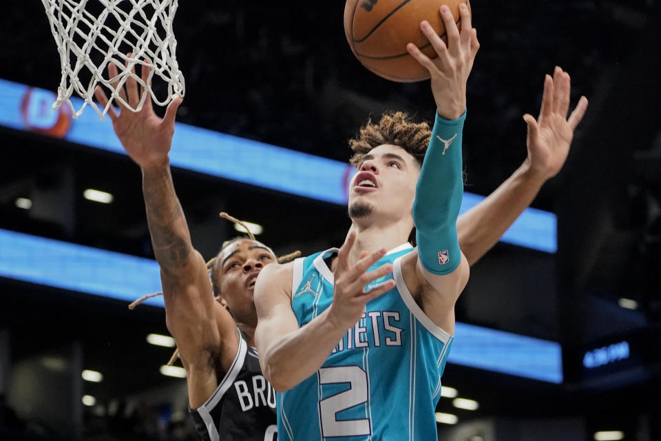 Charlotte Hornets guard LaMelo Ball (2) shoots against Brooklyn Nets forward Nic Claxton, left, during the first half of an NBA basketball game, Sunday, Oct. 24, 2021, in New York. (AP Photo/John Minchillo)