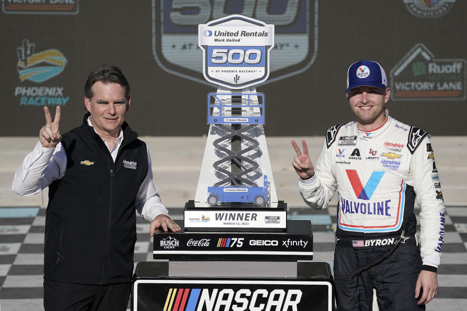 NASCAR legend Jeff Gordon, left, and William Byron, pose with Byron's trophy after winning the NASCAR Cup Series auto race at Phoenix Raceway, Sunday, March 12, 2023, in Avondale, Ariz. (AP Photo/Darryl Webb)