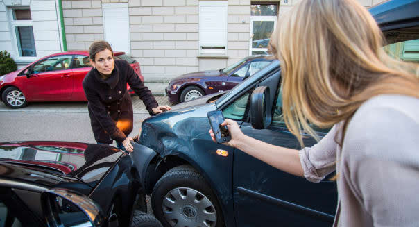 Car accident with minor damage. To woman discus the reason of the car crash, who is guilty.
