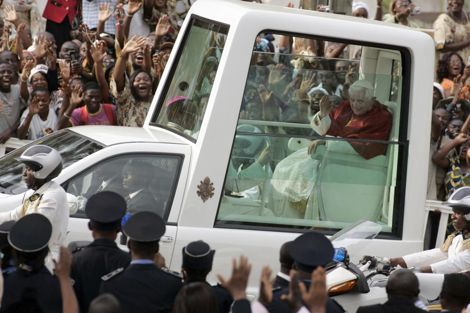 FILE - Pope Benedict XVI waves to the faithful as he arrives to celebrate Vespers at the Basilica in Yaounde, Cameroon, on March 18, 2009. When Cardinal Joseph Ratzinger became Pope Benedict XVI and was thrust into the footsteps of his beloved and charismatic predecessor, he said he felt a guillotine had come down on him. The Vatican announced Saturday Dec. 31, 2022 that Benedict, the former Joseph Ratzinger, had died at age 95. (AP Photo/Rebecca Blackwell, File)