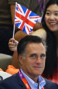 LONDON, ENGLAND - JULY 28: A fan holds a Union Flag over the head of Republican Presidential candidate, former Massachusetts Governor Mitt Romney as he attends the morning swimming session on Day One of the London 2012 Olympic Games at the Aquatics Centre on July 28, 2012 in London, England. (Photo by Al Bello/Getty Images)