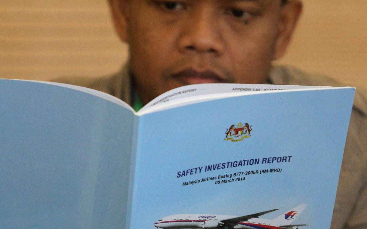 A family member reads an MH370 briefing report before a closed door meeting in Putrajaya - REUTERS