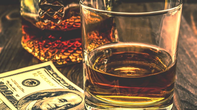bourbon glass on dollar bills