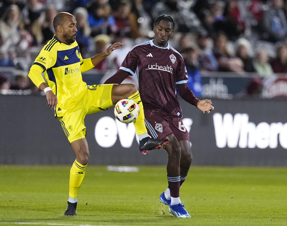 Nashville SC forward Teal Bunbury, left, fights to control the ball as Colorado Rapids defender Moïse Bombito, right, covers during the first half of an MLS soccer match Saturday, March 2, 2024, in Commerce City, Colo. (AP Photo/David Zalubowski)