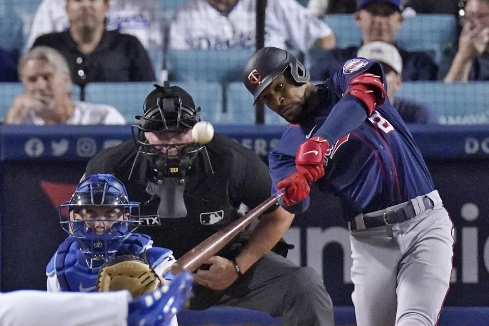Minnesota Twins' Byron Buxton, right, hits a two-run home run as Los Angeles Dodgers catcher Will Smith, left, and home plate umpire Ted Barrett watch during the eighth inning of a baseball game Tuesday, Aug. 9, 2022, in Los Angeles. (AP Photo/Mark J. Terrill)