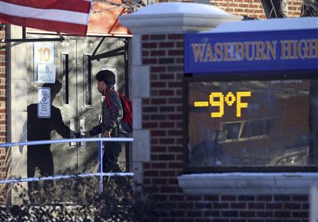 A student enters Washburn High School as the school sign indicates a sub-zero temperature in Minneapolis, January 8, 2014. REUTERS/Eric Miller