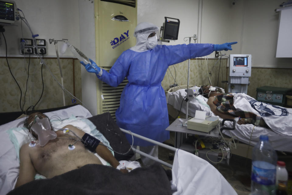 A medic works with corona patientsin a hospital in Idlib, Syria, Saturday, Nov. 14, 2020. At one of two coronavirus hospitals in Syria's rebel-held Idlib province, overwhelmed medical staff tend to patients drifting in and out of consciousness. As confirmed case numbers rise to as many as 500 a day, so does the demand for beds in the intensive care ward (AP Photo/Ghaith Alsayed)