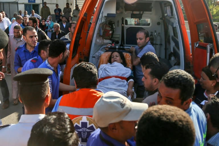 Egyptian medics unload a wounded woman from the back on an ambulance outside a hospital in Cairo's northern suburb of Shubra on May 26, 2017, following an attack in which 28 Coptic pilgirms were gunned down south of the capital