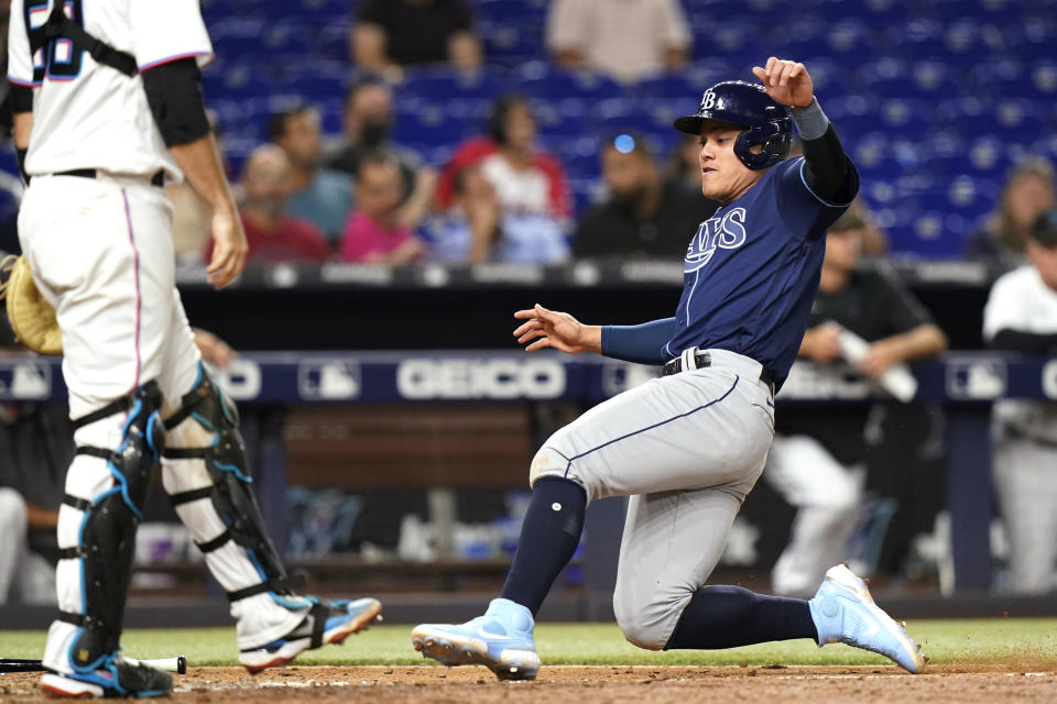 Tampa Bay Rays' Yu Chang, right, scores on a single by Manuel Margot during the 10th inning of the team's baseball game against the Miami Marlins, Wednesday, Aug. 31, 2022, in Miami. (AP Photo/Lynne Sladky)