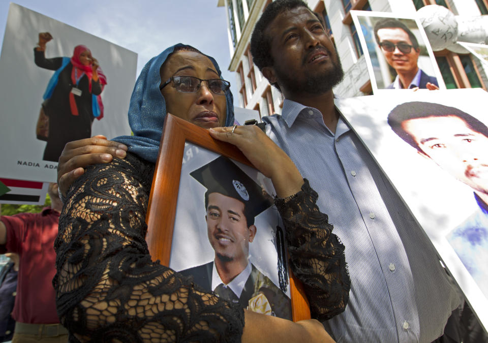 Zinet Adam, left, and Beza Alemu from Ethiopia, hold pictures of their brother Mulusew Alemu, who died in the plane crash, during a vigil on the six-month anniversary of the crash of a Boeing 737 Max 8, killing 157 people, in Ethiopia on March 10, which has resulted in the grounding hundreds of the planes worldwide, outside of the Department of Transportation, Tuesday, Sept. 10, 2019 in Washington. (AP Photo/Jose Luis Magana)