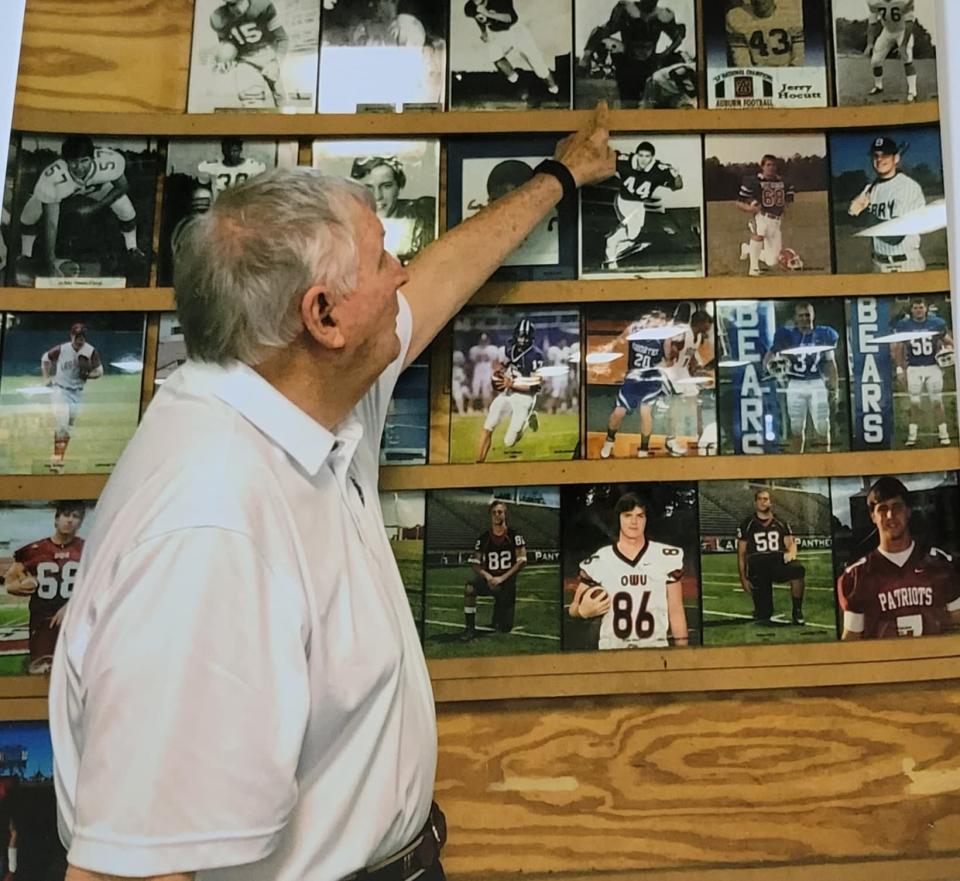 Dr. Jones looks over his old athletics photos at his home in Hendersonville.