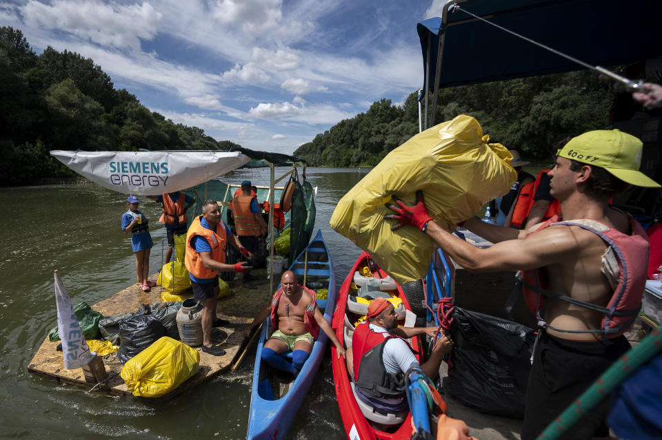 Volunteers offload their boat after it overloaded with collection bags while attending the Plastic Cup event near Tiszaroff, Hungary, on Aug. 2, 2023. Since its start in 2013, participants in the annual Plastic Cup competition — which offers a prize for those who collect the most trash each year — have gathered more than 330 tons (around 727,000 pounds) of waste from the Tisza River and other Hungarian waters. (AP Photo/Denes Erdos)