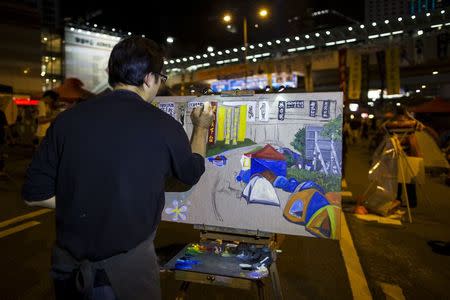 A man paints the scene of protesters camping outside the government headquarters in Hong Kong October 11, 2014. REUTERS/Tyrone Siu