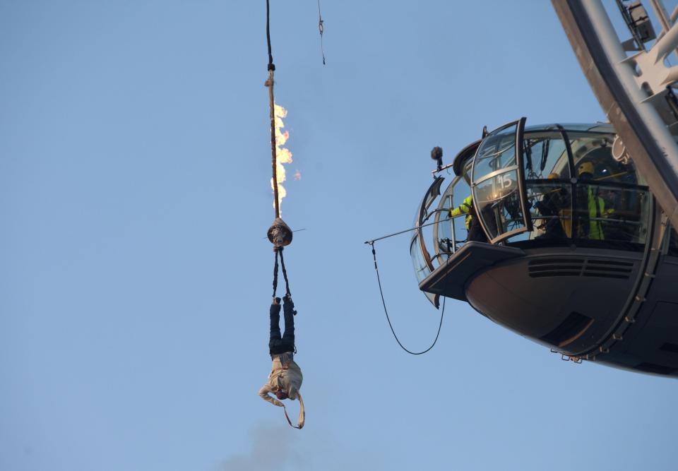 British daredevil Jonathan Goodwin attempting to escape from his blazing straitjacket as he hung high in the air from the EDF Energy London Eye. (PA)