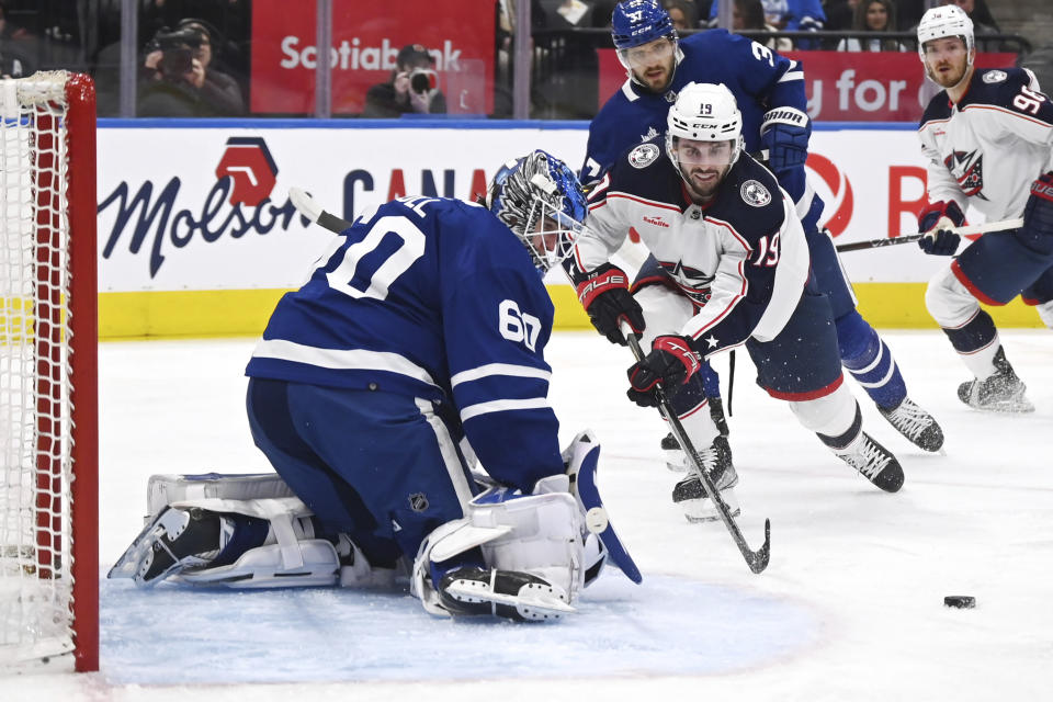 Toronto Maple Leafs goaltender Joseph Woll (60) makes a stop on Columbus Blue Jackets center Liam Foudy (19) during the first period of an NHL hockey game Saturday, Feb. 11, 2023, in Toronto. (Jon Blacker/The Canadian Press via AP)