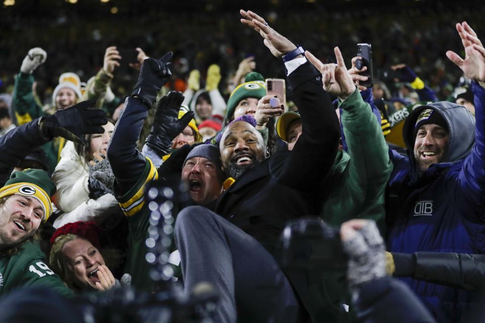 Hall of Famer Charles Woodson does a Lambeau Leap in the crowd after receiving his Hall of Fame ring during halftime ceremony at an NFL football game between the Green Bay Packers and the Los Angeles Rams Sunday, Nov. 28, 2021, in Green Bay, Wis. (AP Photo/Aaron Gash)