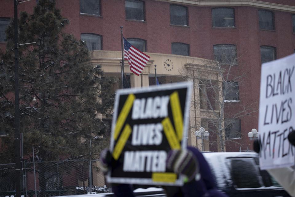 A woman holds a Black Lives Matter sign outside of the Warren E. Burger Federal Building after former Minneapolis police officers J. Alexander Kueng, Tou Thao, and Thomas Lane were found guilty of depriving George Floyd of his right to medical care on Thursday, Feb. 24, 2022, in St. Paul, Minn. (AP Photo/Christian Monterrosa)