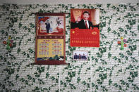 Posters of Chinese President Xi Jinping and his wife Peng Liyuan are displayed on a wall with a photo of members of the Yi minority group inside their home in Xujiashan village in Ganluo County, southwest China's Sichuan province on Sept. 10, 2020. Communist Party Xi’s smiling visage looks down from the walls of virtually every home inhabited by members of the Yi minority group in a remote corner of China’s Sichuan province. Xi has replaced former leader Mao Zedong for pride of place in new brick and concrete homes built to replace crumbling traditional structures in Sichuan’s Liangshan Yi Autonomous Prefecture, which his home to about 2 million members of the group. (AP Photo/Andy Wong)