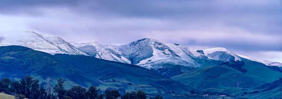 The hills above San Luis Obispo are a blend of white and green after snow dusted the tops on Feb. 25, 2023.