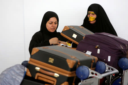 Women check their luggage after arriving on a flight from Dubai on Emirates Flight 203 at John F. Kennedy International Airport in Queens, New York, U.S., January 28, 2017. REUTERS/Andrew Kelly