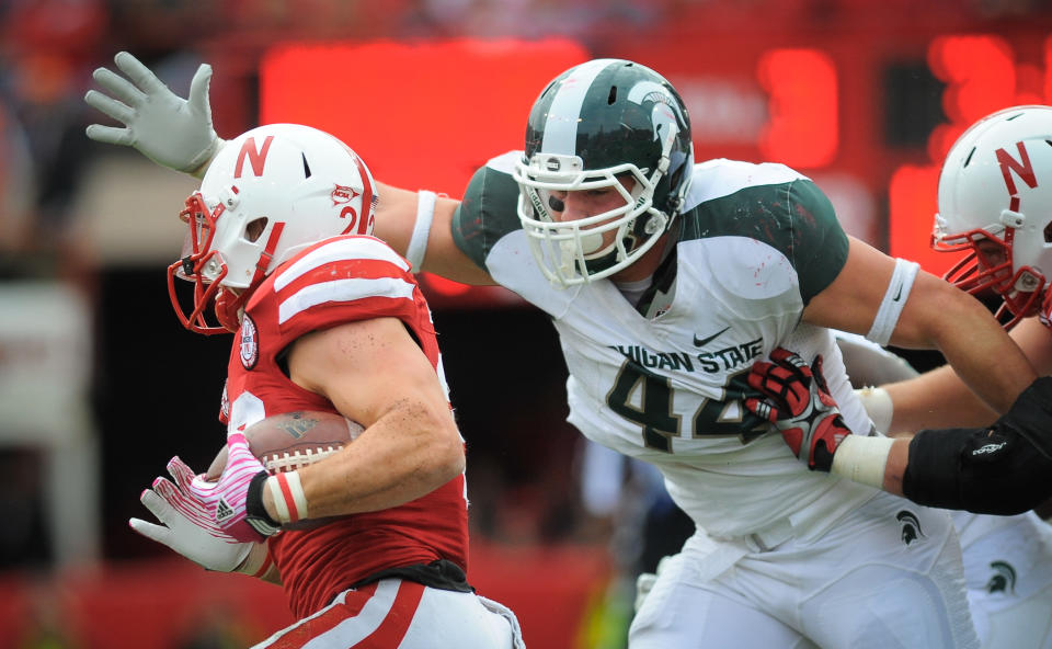 LINCOLN, NE - OCTOBER 29: Linebacker Marcus Rush #44 of the Michigan State Spartans reaches for running back Rex Burkhead #22 of the Nebraska Cornhuskers during their game at Memorial Stadium October 29, 2011 in Lincoln, Nebraska. Nebraska defeated Michigan State 24-3. (Photo by Eric Francis/Getty Images)