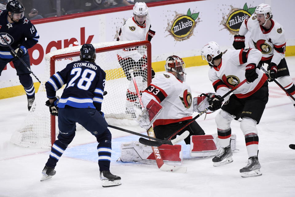 Winnipeg Jets' Kevin Stenlund (28) scores on Ottawa Senators goaltender Cam Talbot (33) during the first period of an NHL hockey game Tuesday, Dec. 20, 2022, in Winnipeg, Manitoba. (Fred Greenslade/The Canadian Press via AP)