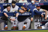 Milwaukee Brewers left fielder Christian Yelich, left and other players watch the game during the ninth inning of Game 3 of a baseball National League Division Series, Monday, Oct. 11, 2021, in Atlanta. The Atlanta Braves won 3-0. (AP Photo/John Bazemore)