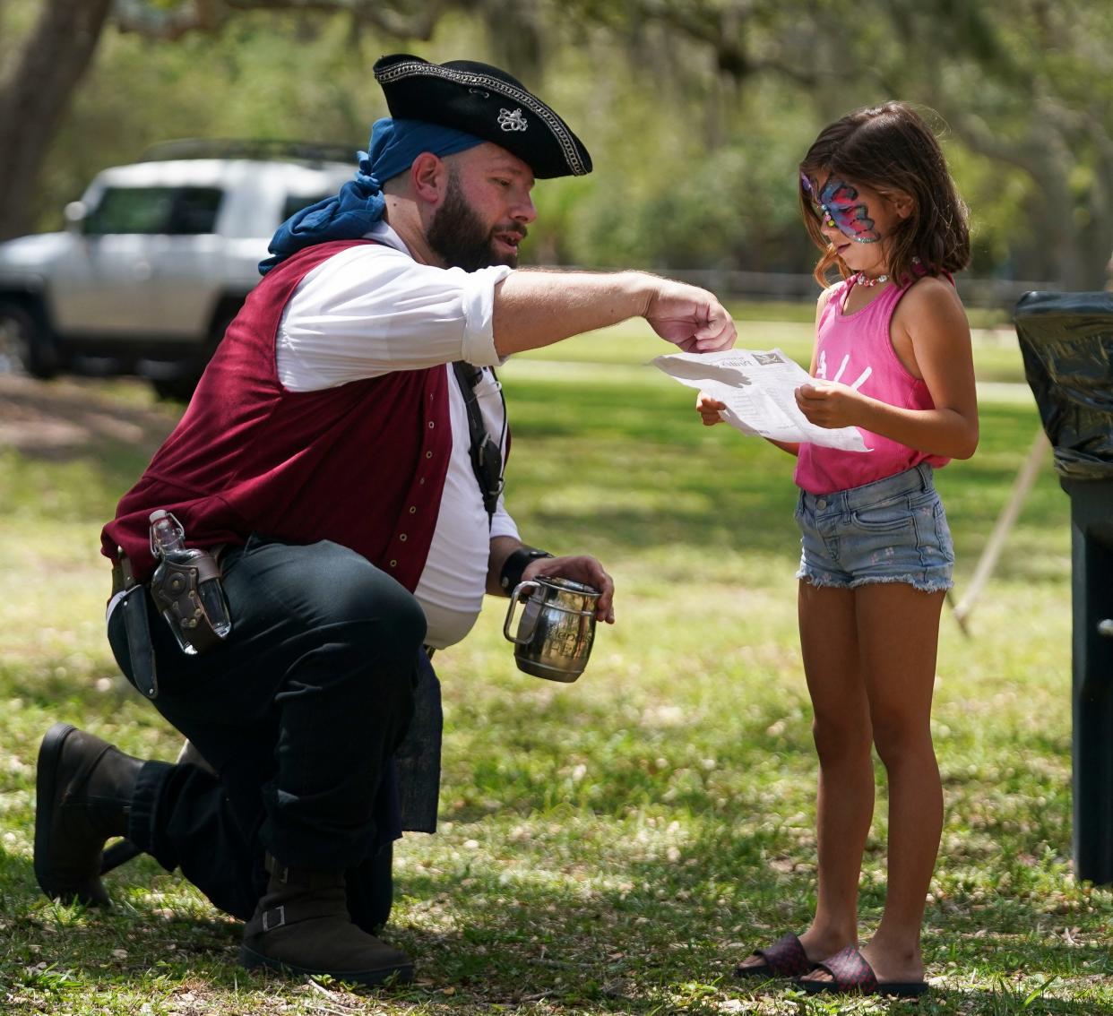 The Vero Beach Seafood Festival is this weekend at Riverside Park. In this photo, pirate Patrick O' Farrel, of the Royal Chessman, helps Laurel Musselman, 7, of Vero Beach, with her pirate quest during last year's festival on May, 13, 2023.