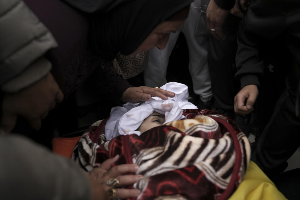 Mourners take a last look at the body of Palestinian Fulla al-Masalmeh,15, during her funeral in the West Bank village of Beit Awwa, Tuesday, Nov. 15, 2022. The Palestinian Health Ministry says Israeli forces shot and killed a 15-year-old Palestinian girl during a pre-dawn raid in the occupied West Bank. The circumstances surrounding the death of the teenage girl in the city of Beitunia in the central West Bank, identified by Palestinian health officials as Fulla al-Masalmeh, were not fully clear. The Israeli military said soldiers opened fire on a vehicle that was accelerating toward them after they signaled for it to stop. The military said it was investigating, and declined to comment further. (AP Photo/Mahmoud Illean)